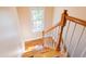 Bright staircase featuring a window, wood treads, white risers, and wood railing at 765 Carlton St, Clayton, NC 27520