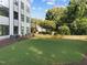 The backyard is a fully landscaped green lawn with views of mature trees and a modern building at 810 Maple Berry Ln # 105, Raleigh, NC 27607