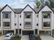 Modern townhome exterior featuring black trim, white siding, a garage, and driveway at 810 Maple Berry Ln # 105, Raleigh, NC 27607