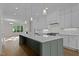 Bright, open kitchen with stainless steel appliances, white cabinets, and a large island with quartz countertops at 810 Maple Berry Ln # 105, Raleigh, NC 27607