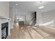 Spacious living room with hardwood floors, fireplace, and open layout connecting to the kitchen and staircase at 810 Maple Berry Ln # 105, Raleigh, NC 27607