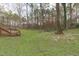 Expansive backyard with lush greenery, mature trees, and a wooden deck at 900 Stoneybrook Dr, Sanford, NC 27330