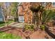 Brick home's backyard offers a wooden pergola over a stone patio, and well-maintained landscaping at 9320 Teton Pines Way, Raleigh, NC 27617