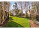 Spacious backyard featuring a well-kept lawn, iron fence and mature trees, perfect for outdoor enjoyment at 9320 Teton Pines Way, Raleigh, NC 27617