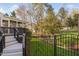 Backyard with an iron fence, lush green grass, and a screened-in porch in the background at 9320 Teton Pines Way, Raleigh, NC 27617