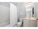 Bright bathroom featuring a tub with a shower, neutral finishes and vanity with updated mirror at 9320 Teton Pines Way, Raleigh, NC 27617