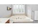 Close up of bathtub with neutral tile surround and window view at 9320 Teton Pines Way, Raleigh, NC 27617