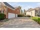 Expansive driveway leading to a three-car garage, with basketball hoop near a grassy area at 9320 Teton Pines Way, Raleigh, NC 27617