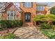 Inviting front entrance with a black double door, brick steps and manicured shrubbery at 9320 Teton Pines Way, Raleigh, NC 27617