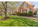 Charming brick home with a lush, green front yard and manicured hedges. Stone walkway leads to the front door at 9320 Teton Pines Way, Raleigh, NC 27617