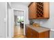 Hallway featuring wood cabinetry, stone countertops, and seamless access to dining room at 9320 Teton Pines Way, Raleigh, NC 27617