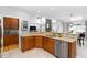 Modern kitchen features stainless steel dishwasher, wooden cabinetry, and seamless access to living area at 9320 Teton Pines Way, Raleigh, NC 27617