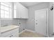 Laundry room with sink, cabinetry, and exterior door at 9320 Teton Pines Way, Raleigh, NC 27617