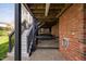 Lower level brick patio with stairs to the deck and a glimpse of the hot tub creating an entertainment area at 9320 Teton Pines Way, Raleigh, NC 27617