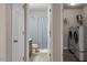 Hallway showcasing a bathroom and a laundry room equipped with modern washer and dryer units at 1008 Garden Square Ln, Morrisville, NC 27560