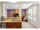 Open kitchen and dinette area with tile backsplash, stainless steel appliances, and wood accent wall at 1008 Garden Square Ln, Morrisville, NC 27560