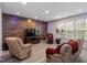 Spacious living room featuring a wood-paneled accent wall, modern lighting, and lots of natural light at 1008 Garden Square Ln, Morrisville, NC 27560