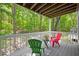 Outdoor deck with red and green chairs overlooking a beautiful wooded area, perfect for relaxation at 101 Hunting Chase # 2B, Cary, NC 27513