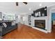 Open-concept living room featuring a fireplace with TV, hardwood floors, and views of the kitchen at 101 Hunting Chase # 2B, Cary, NC 27513