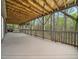 Spacious covered back porch with wood beam ceiling offering views of the surrounding natural forest at 109 Barcliff Ter, Cary, NC 27518