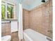 Bright bathroom with tiled shower/tub combination and light-filled window views at 109 Barcliff Ter, Cary, NC 27518
