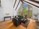 Bright living room featuring large windows, exposed ceiling beams, and wood floors, offering a seamless connection with nature at 109 Barcliff Ter, Cary, NC 27518