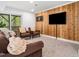 Inviting living room featuring wood-paneled wall, comfortable seating, and sliding glass doors to outdoor greenery at 109 Barcliff Ter, Cary, NC 27518
