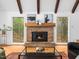 Inviting living room features a stone fireplace with striking wooden beams and light filled windows overlooking a wooded lot at 109 Barcliff Ter, Cary, NC 27518