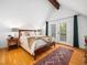 Comfortable main bedroom with vaulted ceiling, wooden floors, and doors opening to balcony at 109 Barcliff Ter, Cary, NC 27518