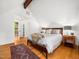 Bright main bedroom featuring wooden floors, vaulted ceiling, doors opening to balcony, and ensuite bath at 109 Barcliff Ter, Cary, NC 27518