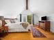 Comfortable main bedroom with wooden floors, vaulted ceiling, and doors opening to balcony at 109 Barcliff Ter, Cary, NC 27518