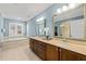 Elegant bathroom with a double vanity, soaking tub, tile flooring, and a large framed mirror at 113 Bennett Mountain Trce, Chapel Hill, NC 27516