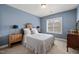 Comfortable bedroom with blue walls, carpet, and a large window providing natural light at 113 Bennett Mountain Trce, Chapel Hill, NC 27516
