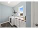 Functional laundry room with modern appliances, a built-in sink, and natural light from the window at 113 Bennett Mountain Trce, Chapel Hill, NC 27516