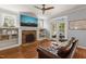 Cozy living room with stone fireplace, built-in shelves, ceiling fan, and access to outdoor patio at 113 Bennett Mountain Trce, Chapel Hill, NC 27516