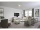Comfortable living area featuring a modern entertainment center, neutral decor, and bright windows at 1164 Solace Way, Rolesville, NC 27571