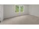 Neutral bedroom with light carpet and two large windows at 1173 Solace Way, Rolesville, NC 27571