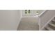 Spacious living room with plush carpeting, three bright windows, and stairwell at 1173 Solace Way, Rolesville, NC 27571