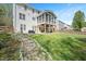 Spacious backyard with a screened porch, patio, lush lawn and stone path at 118 Benedum Pl, Cary, NC 27518