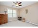 Neutral bedroom featuring a dresser, ceiling fan, and a window bringing in lots of natural light at 118 Benedum Pl, Cary, NC 27518