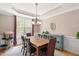 Bright dining room featuring a large window, modern chandelier, and stylish decor at 118 Benedum Pl, Cary, NC 27518
