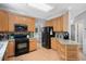 Well-lit kitchen featuring wooden cabinets, granite countertops, and stainless steel appliances at 118 Benedum Pl, Cary, NC 27518