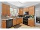 Updated kitchen boasts granite countertops, wooden cabinets, and stainless steel dishwasher at 118 Benedum Pl, Cary, NC 27518