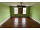Bedroom with hardwood floors, neutral colors, windows, and traditional ceiling fan at 121 W Young Ave, Henderson, NC 27536