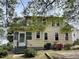 Rear exterior view of a two-story home with a small porch and well-maintained yard at 121 W Young Ave, Henderson, NC 27536
