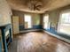 Well-lit living room with classic windows, fireplace, and ample space to renovate at 121 W Young Ave, Henderson, NC 27536