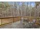 Outdoor deck with seating, providing a relaxing space surrounded by a wooded area at 125 Camden Dr, Youngsville, NC 27596