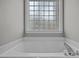 Bright bathroom with a soaking tub and unique glass block window for privacy at 125 Camden Dr, Youngsville, NC 27596