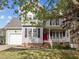 Charming two-story home featuring gray siding, black shutters, a red front door, and a welcoming front porch at 125 Camden Dr, Youngsville, NC 27596