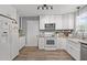 Well-lit kitchen with white cabinetry, stainless steel appliances, and laminate flooring at 125 Camden Dr, Youngsville, NC 27596